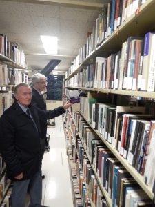 Minister Žmavc in prof. dr. Biggins si ogledujeta slovensko knjižno zbirko
